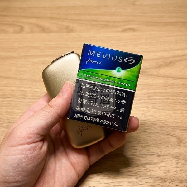 手拿Ploom加熱菸口味MEVIUS七星 Muscat Green Option麝香葡萄爆珠口味煙彈包裝盒正面展示